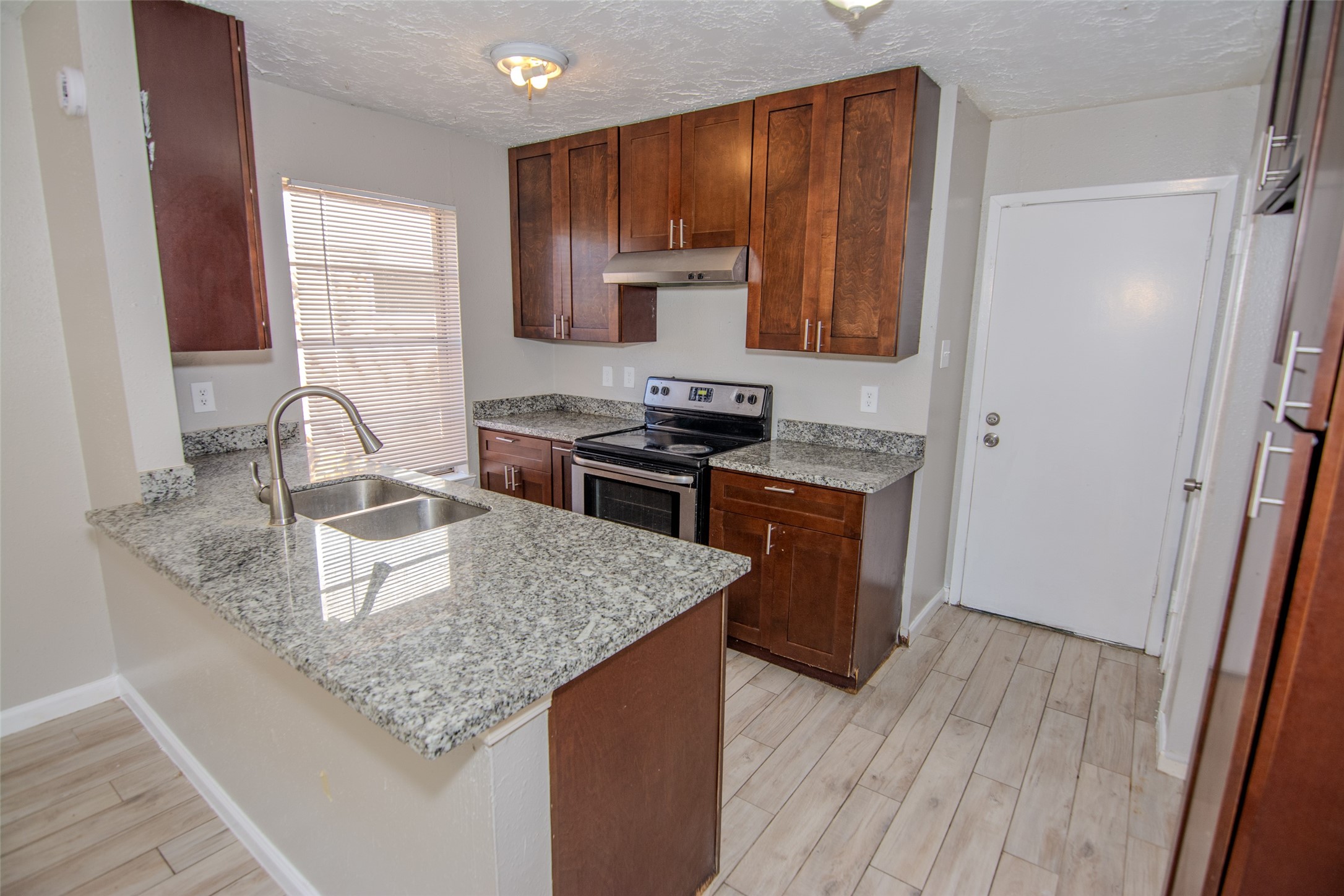 20031 Woodhall Lane Humble, TX 77338 - Photo 7 of 16 a kitchen with granite countertop a sink a stove and cabinets