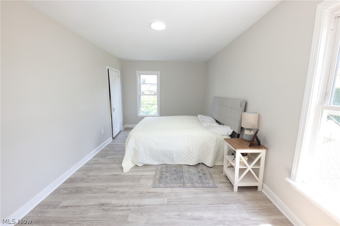 416 5th Street Chester, WV 26034 - Photo 11 of 24 Light-filled room featuring light gray walls, wood-finish flooring, a white trim package, and a window with natural light