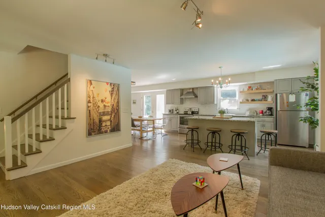 a living room with furniture and a dining table with wooden floor