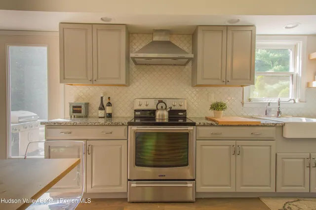 a kitchen with white cabinets appliances and a sink