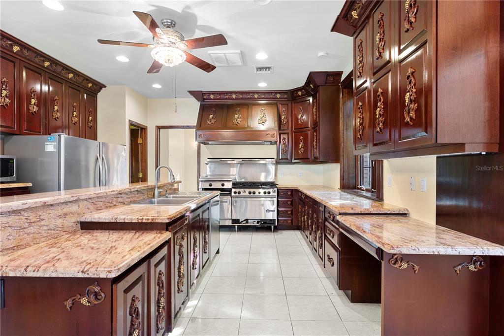1577 Alexander Road Belleair, FL 33756 - Photo 29 of 65 a kitchen with stainless steel appliances granite countertop a sink and cabinets