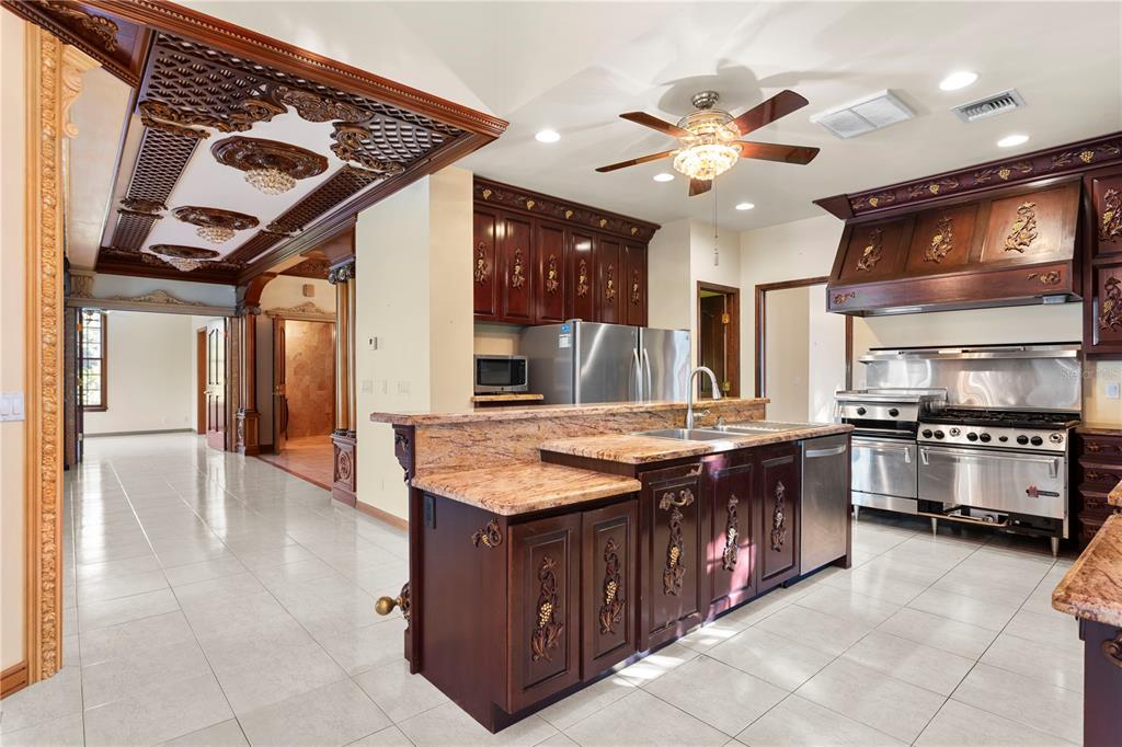 1577 Alexander Road Belleair, FL 33756 - Photo 30 of 65 a kitchen with stainless steel appliances granite countertop a stove and a kitchen island