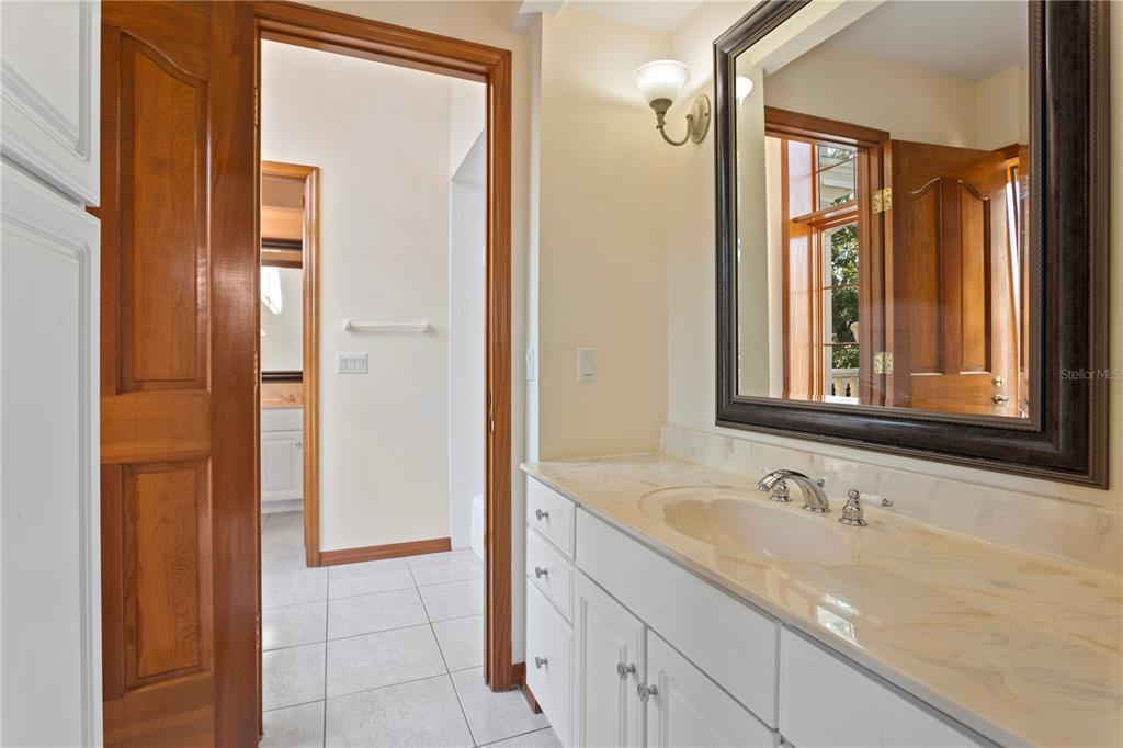 1577 Alexander Road Belleair, FL 33756 - Photo 46 of 65 a bathroom with a granite countertop sink and a mirror