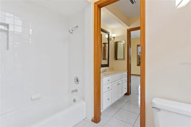 a spacious bathroom with a double vanity sink a mirror and a bathtub