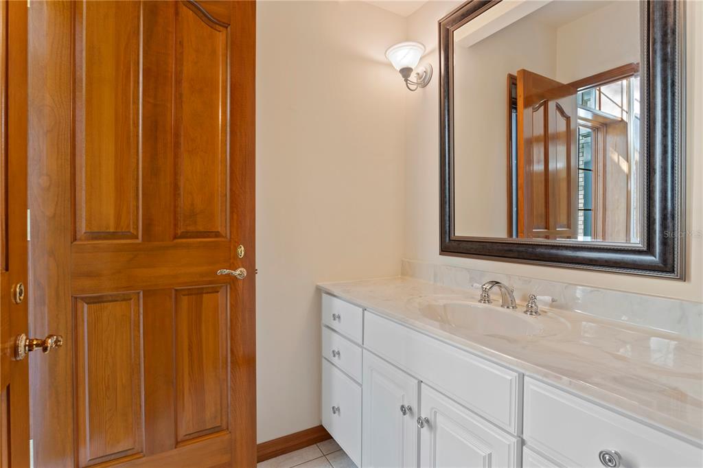 1577 Alexander Road Belleair, FL 33756 - Photo 48 of 65 a bathroom with a sink a mirror and a window