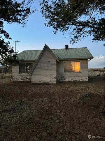 a view of a wooden house with large trees