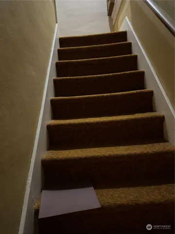 a view of a hallway with wooden floor and stairs