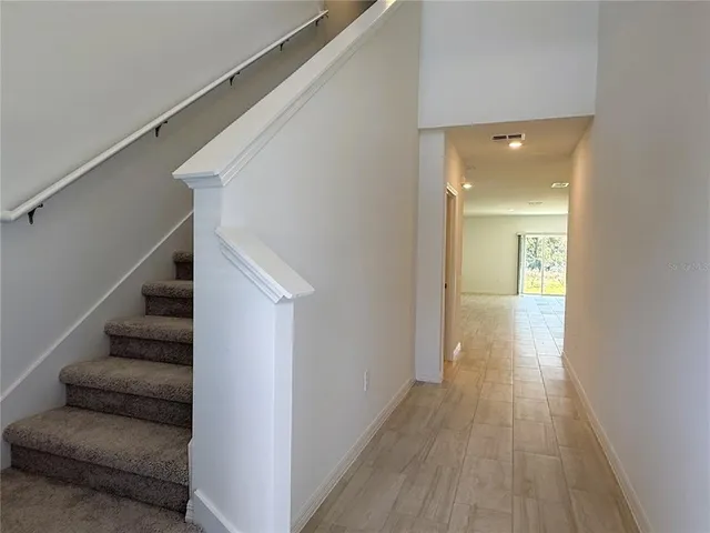 a view of a hallway with wooden floor and entryway