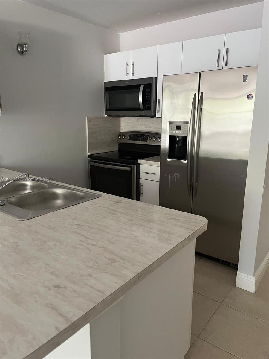 2701 Riverside Drive, Unit 203B Coral Springs, FL 33065 - Photo 6 of 18 a kitchen with stainless steel appliances a refrigerator and a stove