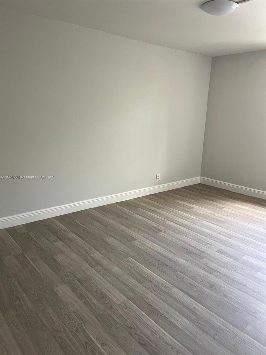 2701 Riverside Drive, Unit 203B Coral Springs, FL 33065 - Photo 9 of 18 a view of an empty room with wooden floor