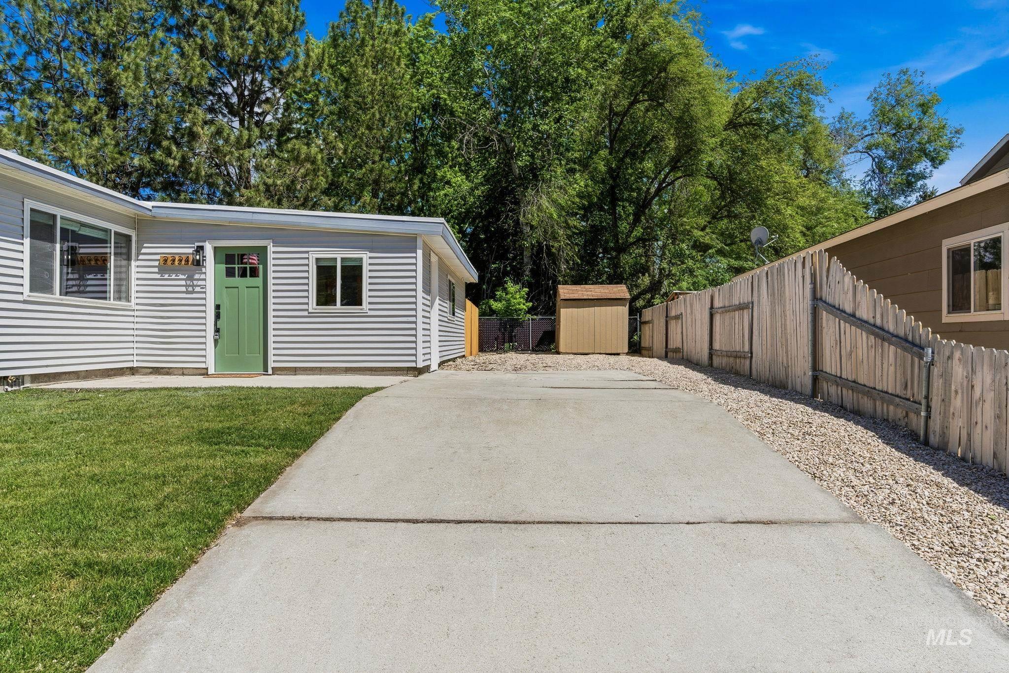 2224 Rachel Circle Boise, ID 83706 - Photo 4 of 50 Property exterior featuring light gray siding, a vibrant green entry door with window panes, and a concrete driveway