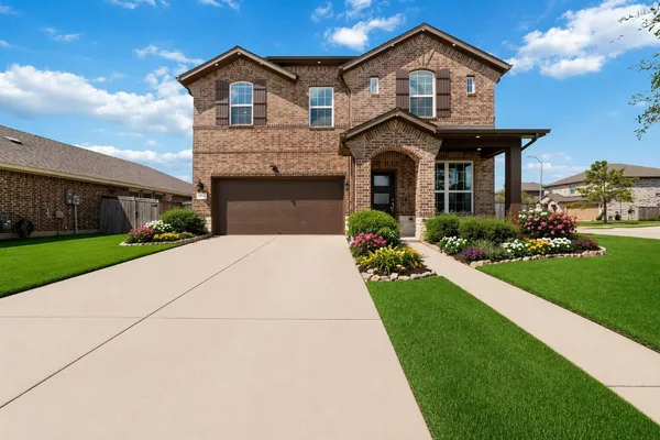 a front view of a house with a yard and potted plants