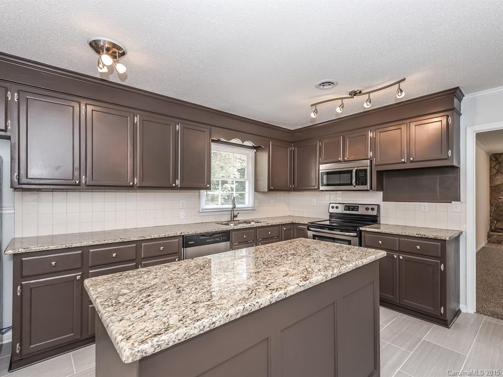 2314 Goldmine Road Monroe, NC 28110 - Photo 13 of 24 a kitchen with stainless steel appliances granite countertop a sink stove microwave and cabinets