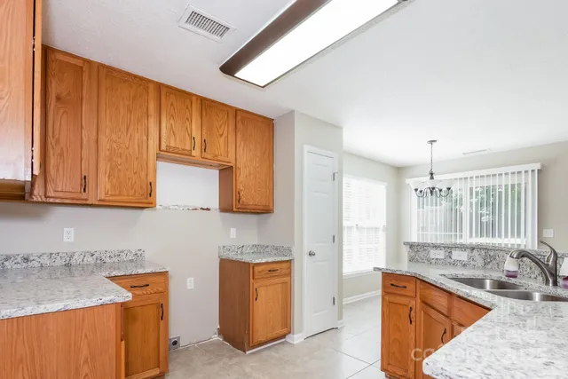 a kitchen with granite countertop a sink stove and cabinets