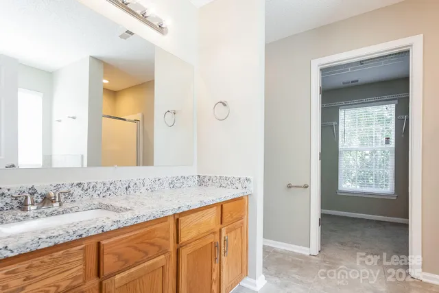 a bathroom with a granite countertop sink and a mirror