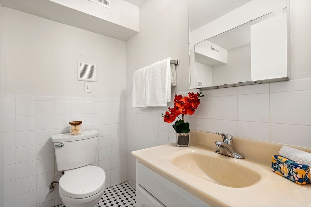120 Beaconsfield Road, Unit 12 Brookline, MA 02445 - Photo 13 of 32 a bathroom with a sink a toilet and a mirror