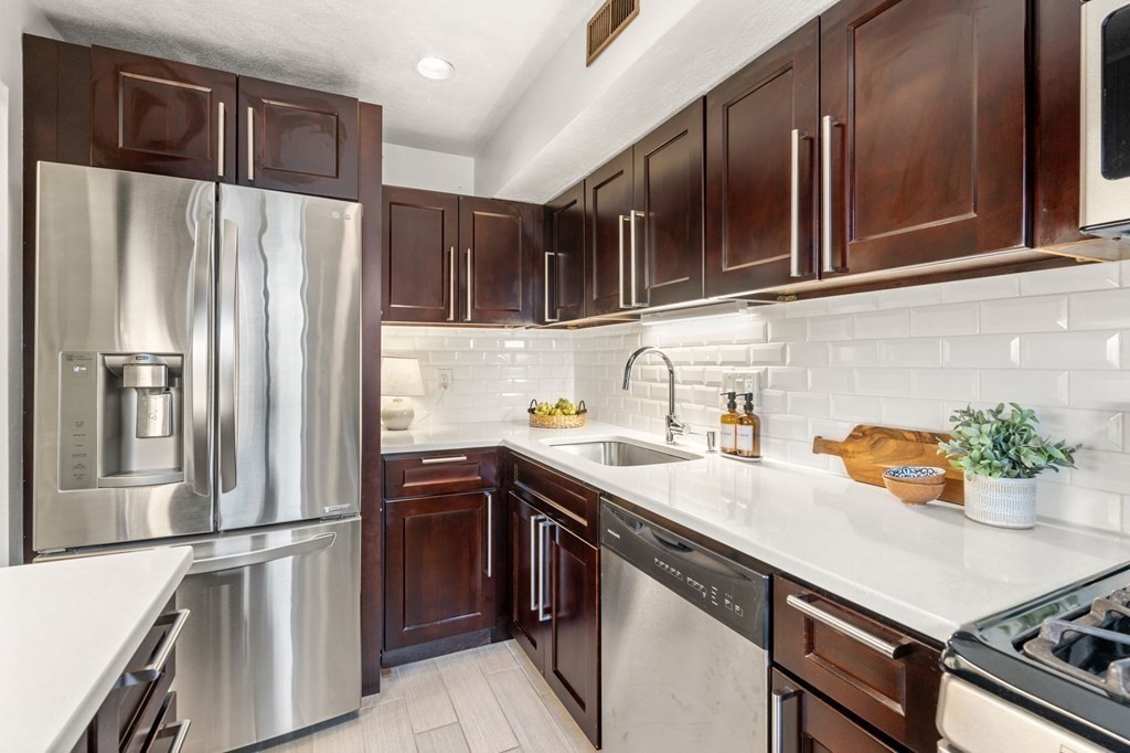120 Beaconsfield Road, Unit 12 Brookline, MA 02445 - Photo 3 of 32 a kitchen with stainless steel appliances a sink and a refrigerator