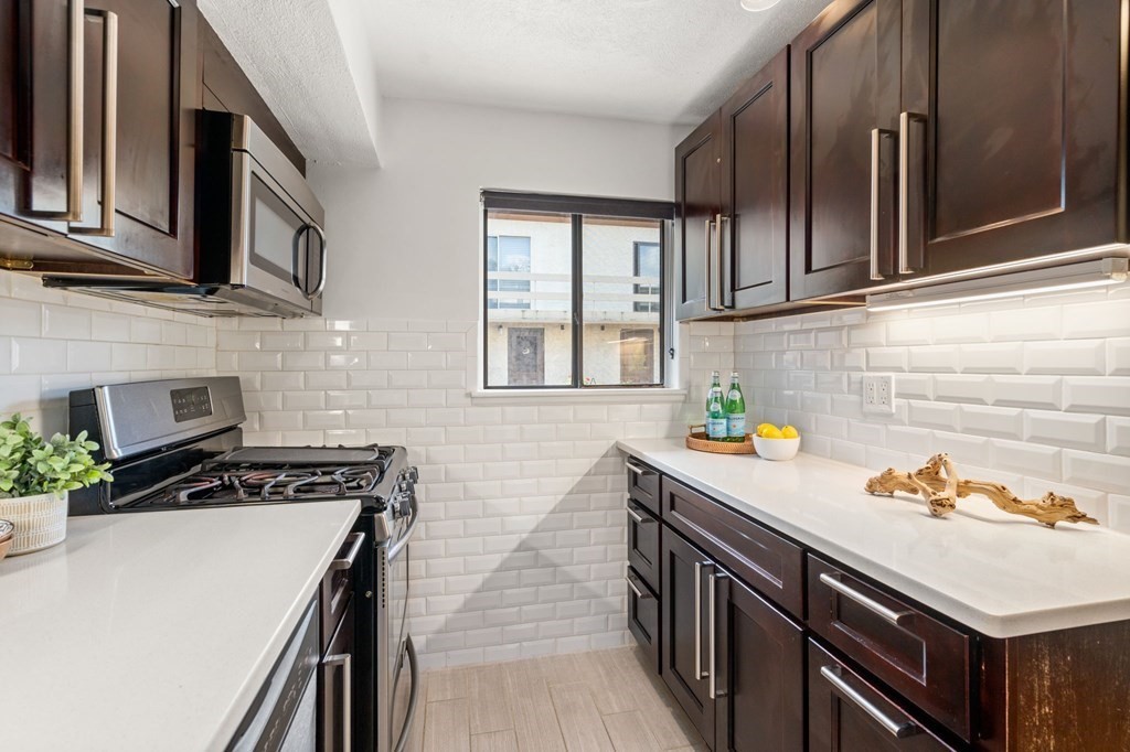 120 Beaconsfield Road, Unit 12 Brookline, MA 02445 - Photo 4 of 32 a kitchen with stainless steel appliances a sink stove and cabinets