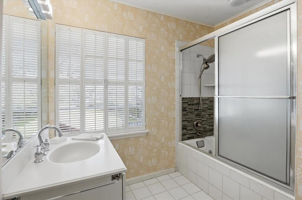 6321 Greenway Road Fort Worth, TX 76116 - Photo 29 of 40 Full bath featuring vanity, wallpapered walls, tiled shower / bath combo, light tile patterned floors, and crown molding