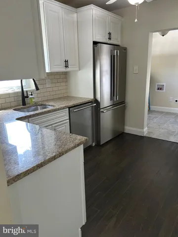 a kitchen with stainless steel appliances granite countertop white cabinets and stove