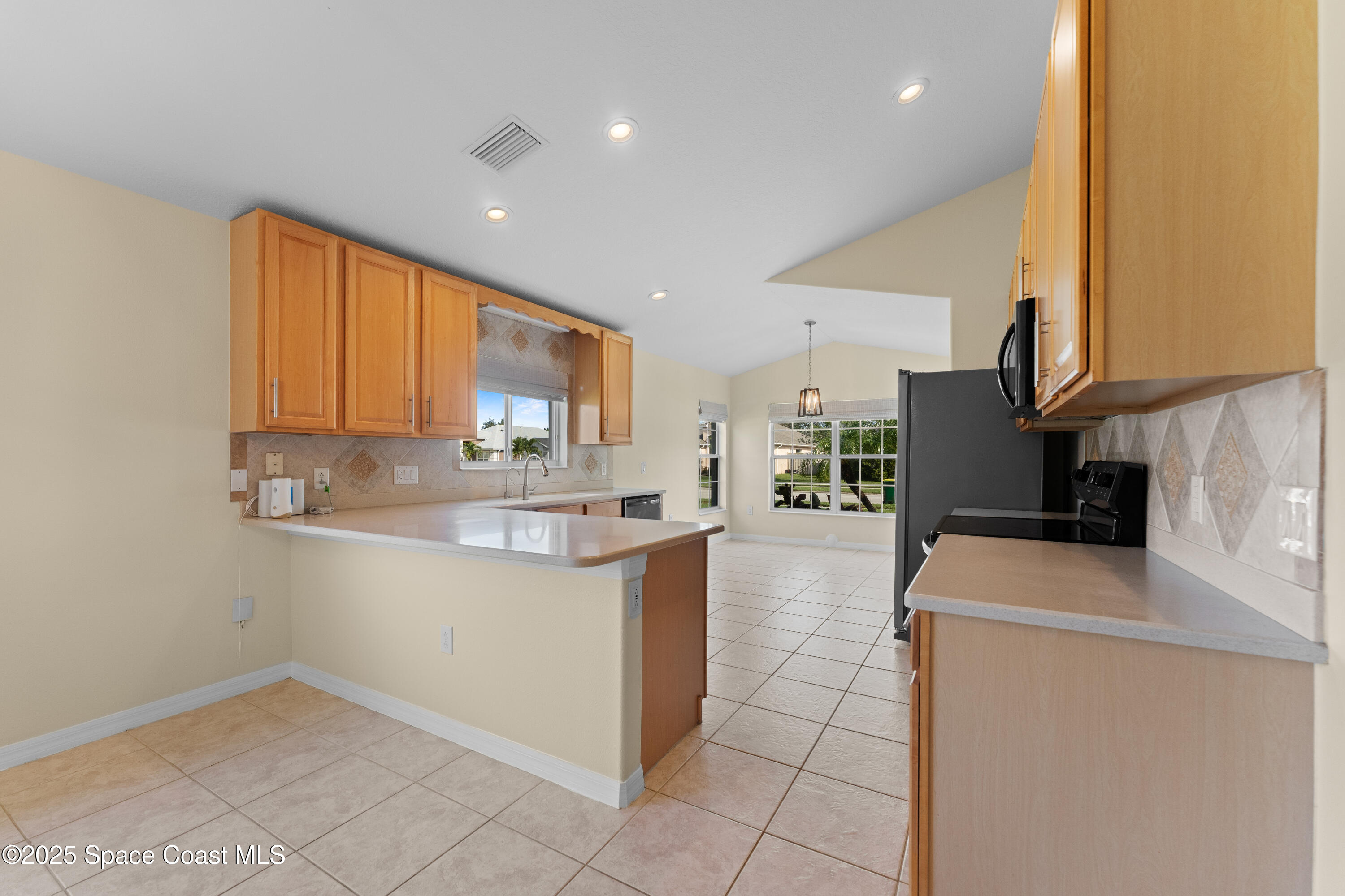 3112 Siderwheel Drive Rockledge, FL 32955 - Photo 16 of 60 a kitchen with stainless steel appliances granite countertop a sink a stove and a refrigerator