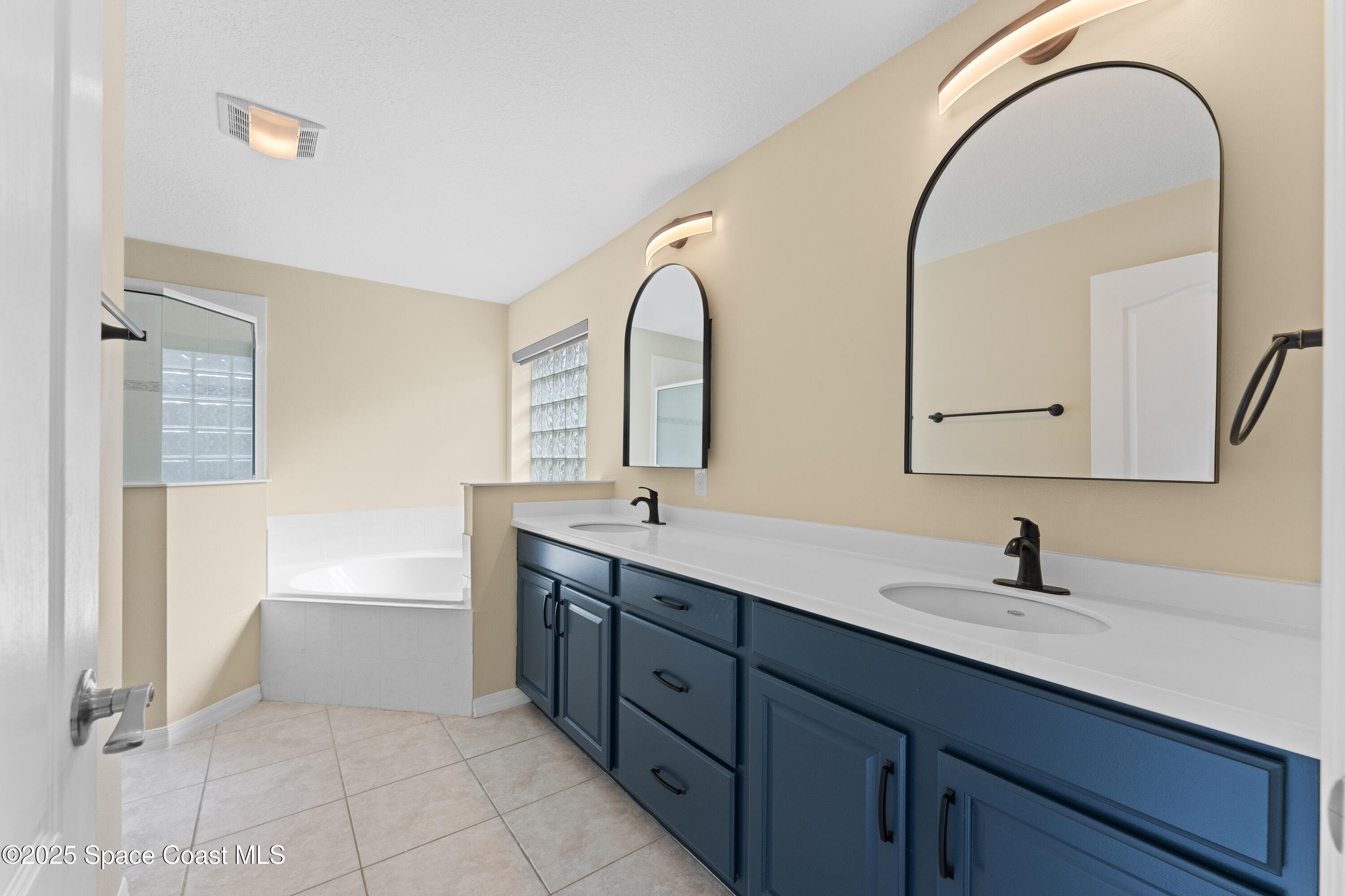 3112 Siderwheel Drive Rockledge, FL 32955 - Photo 23 of 60 a bathroom with a double vanity sink and a mirror