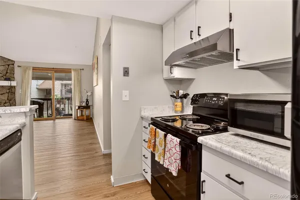 a kitchen with wooden floor and a stove top oven