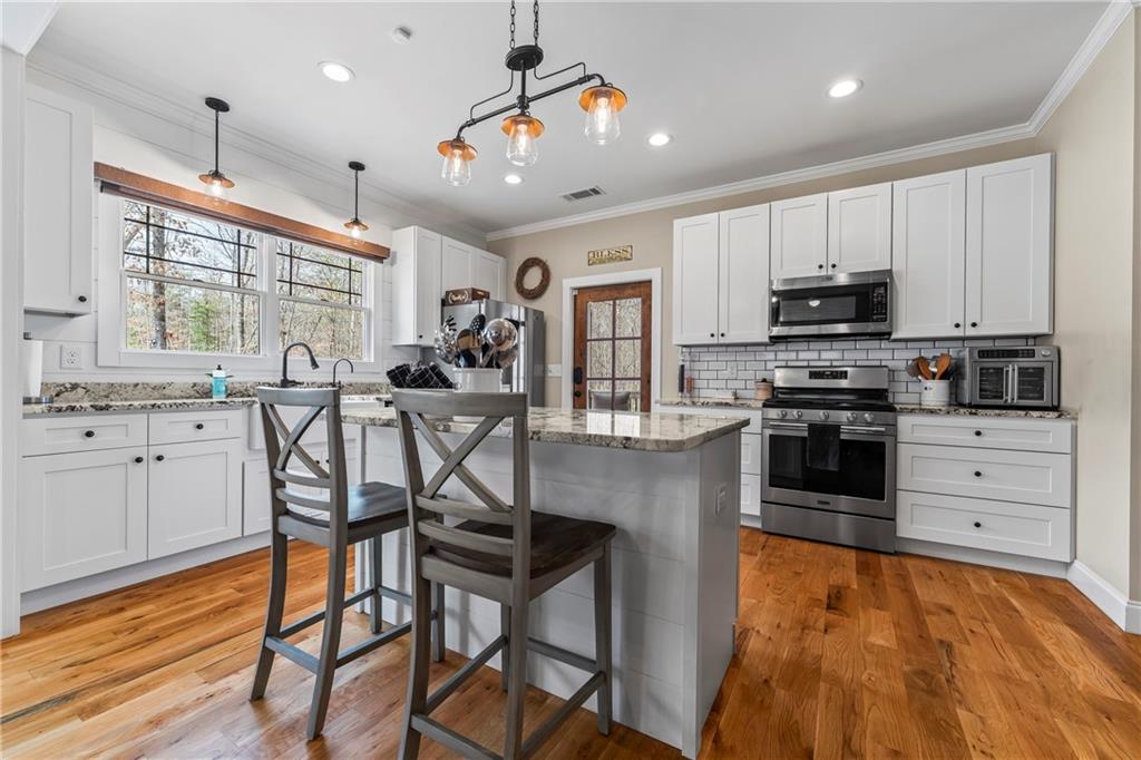 5240 Highway 17 Clarkesville, GA 30523 - Photo 34 of 82 a kitchen with stainless steel appliances kitchen island granite countertop a stove a sink and a refrigerator