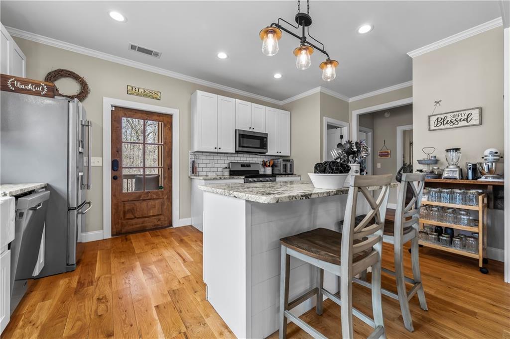 5240 Highway 17 Clarkesville, GA 30523 - Photo 35 of 82 a kitchen with stainless steel appliances kitchen island granite countertop a stove a refrigerator a sink a dining table and chairs with wooden floor