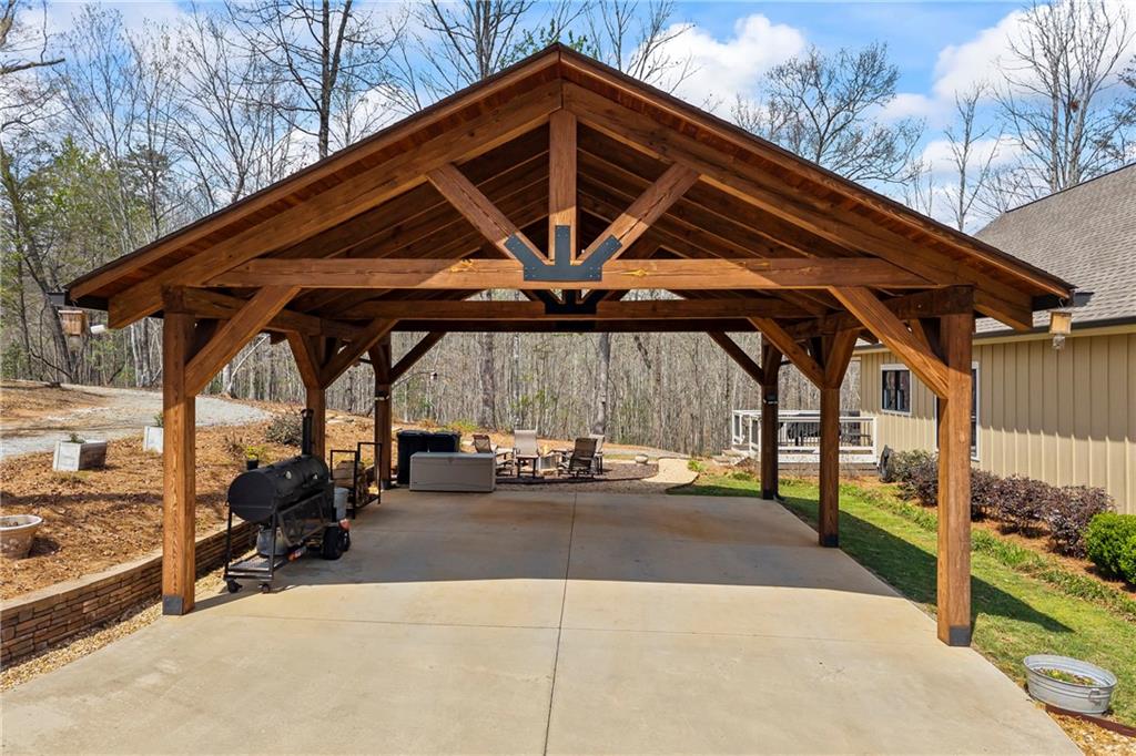5240 Highway 17 Clarkesville, GA 30523 - Photo 9 of 82 a view of patio with table and chairs under an umbrella with a barbeque grill and couches