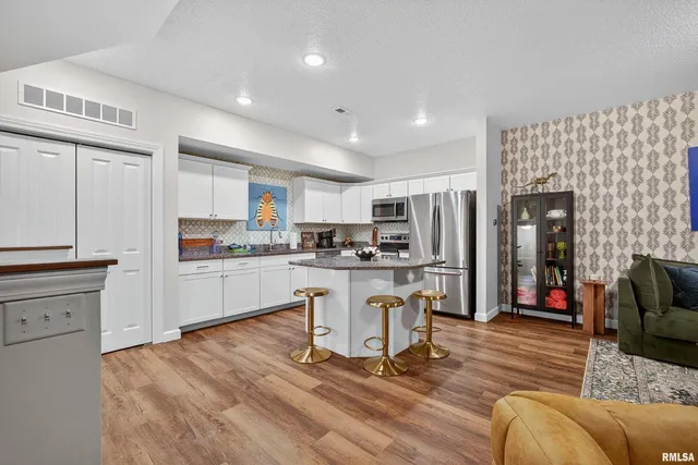 a kitchen with white cabinets and refrigerator
