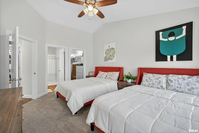 a bedroom with two beds and painting on the wall