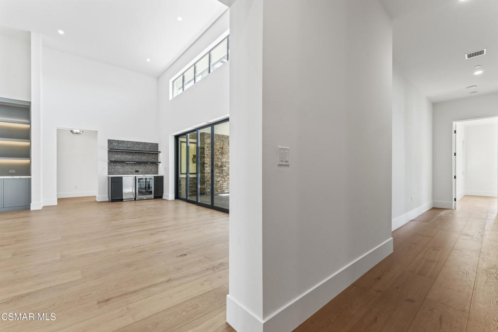 532 Corte Corrida Camarillo, CA 93010 - Photo 27 of 76 a view of an empty room with wooden floor and a kitchen