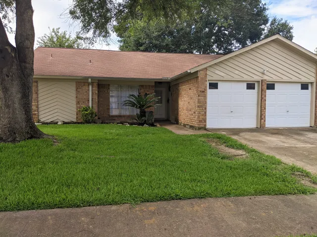 a view of a white house with a large yard and large tree