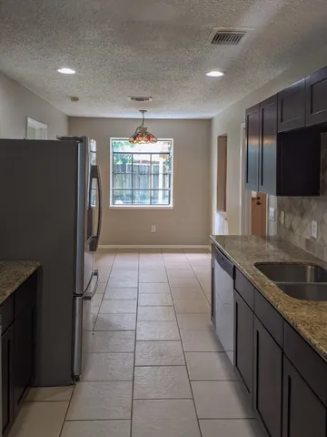 a kitchen with stainless steel appliances granite countertop a refrigerator and a sink