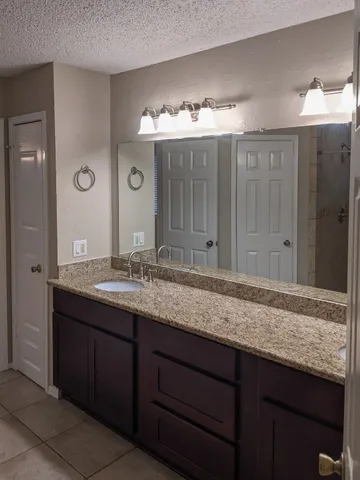a bathroom with a granite countertop sink and a mirror