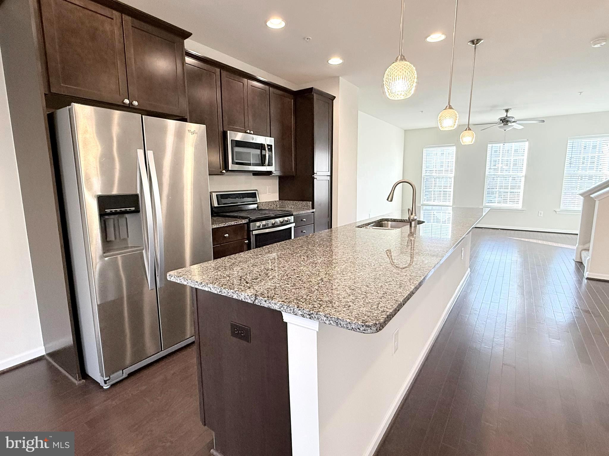 6082 Forum Square Frederick, MD 21703 - Photo 21 of 63 a kitchen with stainless steel appliances granite countertop a refrigerator a sink a stove and a wooden floors