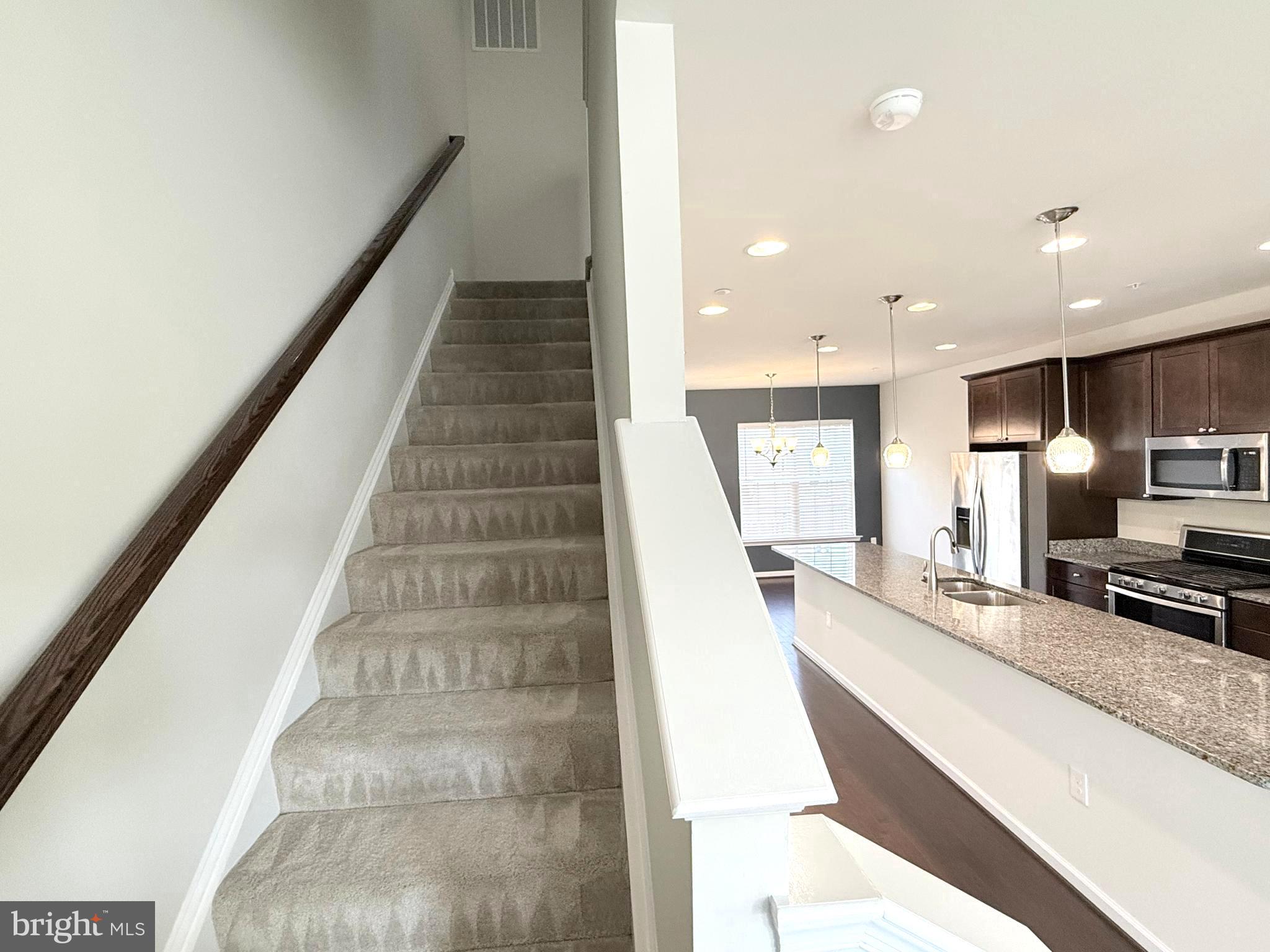 6082 Forum Square Frederick, MD 21703 - Photo 32 of 63 a view of a kitchen with kitchen island wooden floor and stainless steel appliances
