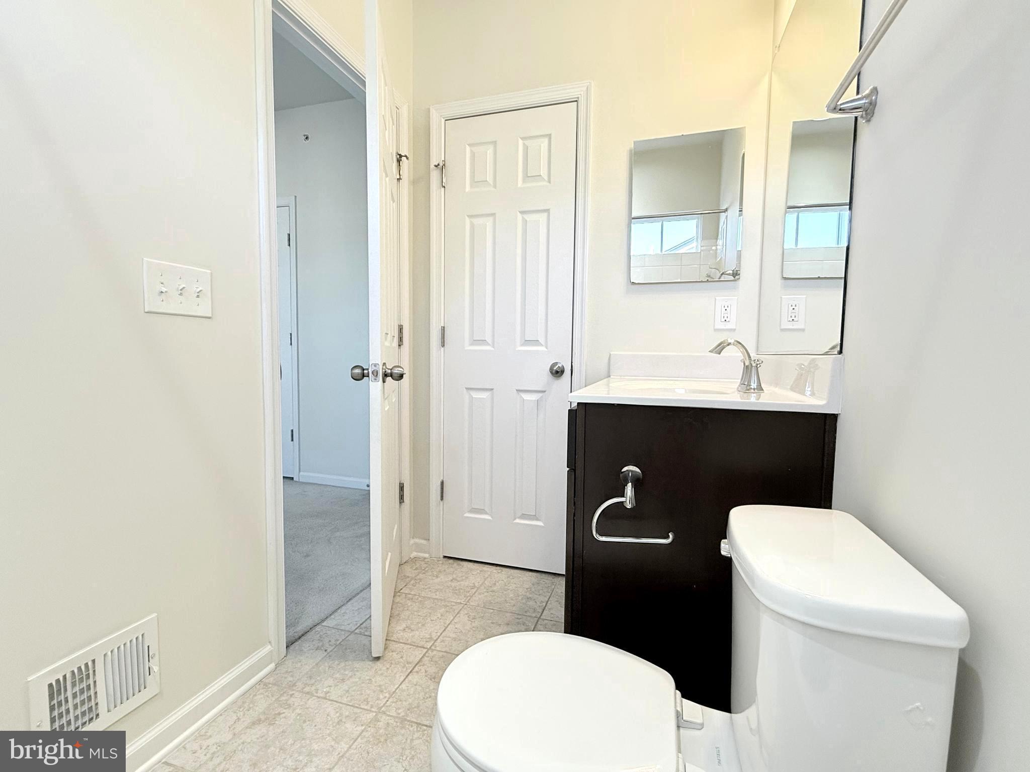 6082 Forum Square Frederick, MD 21703 - Photo 38 of 63 a bathroom with a toilet a sink a vanity and mirror