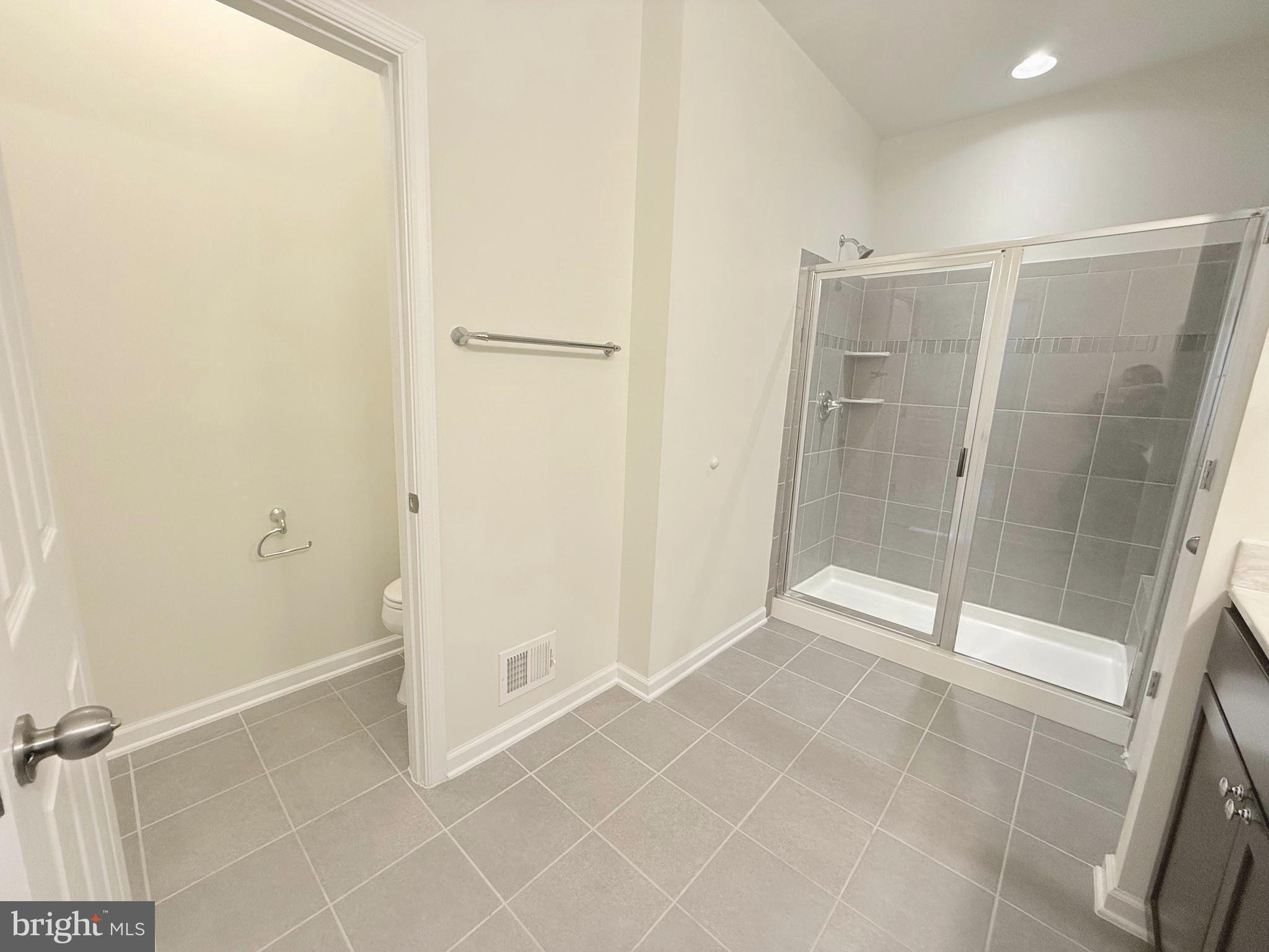 6082 Forum Square Frederick, MD 21703 - Photo 49 of 63 a bathroom with a shower and a glass door