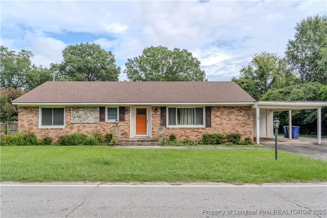 a front view of a house with a yard and potted plants