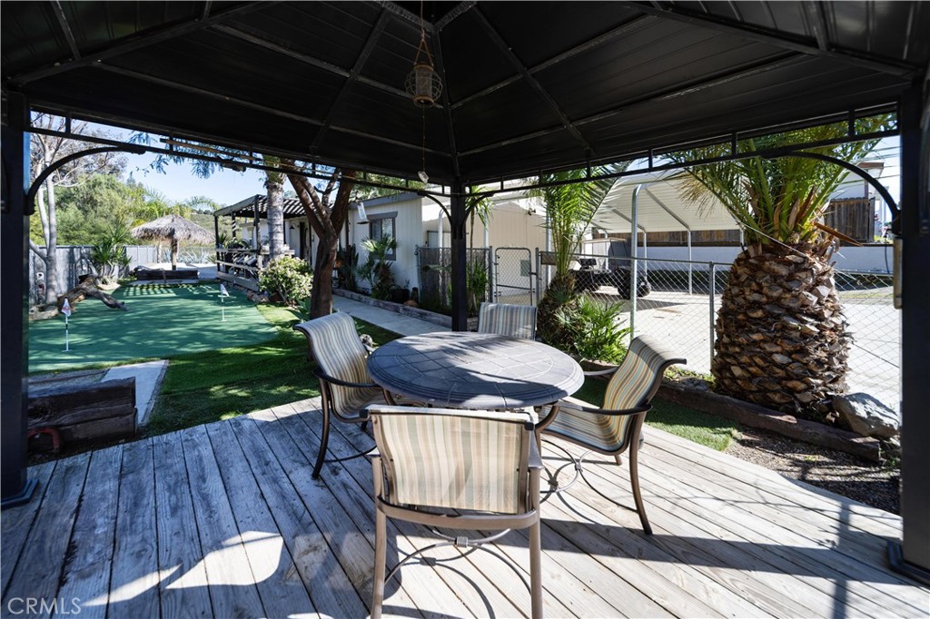 33671 The Farm Road Wildomar, CA 92595 - Photo 44 of 73 a view of a patio with table and chairs under an umbrella
