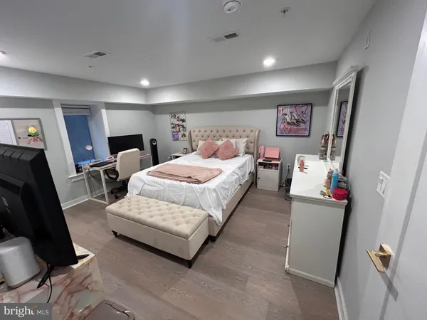 a bedroom with a bed a couch and dresser
