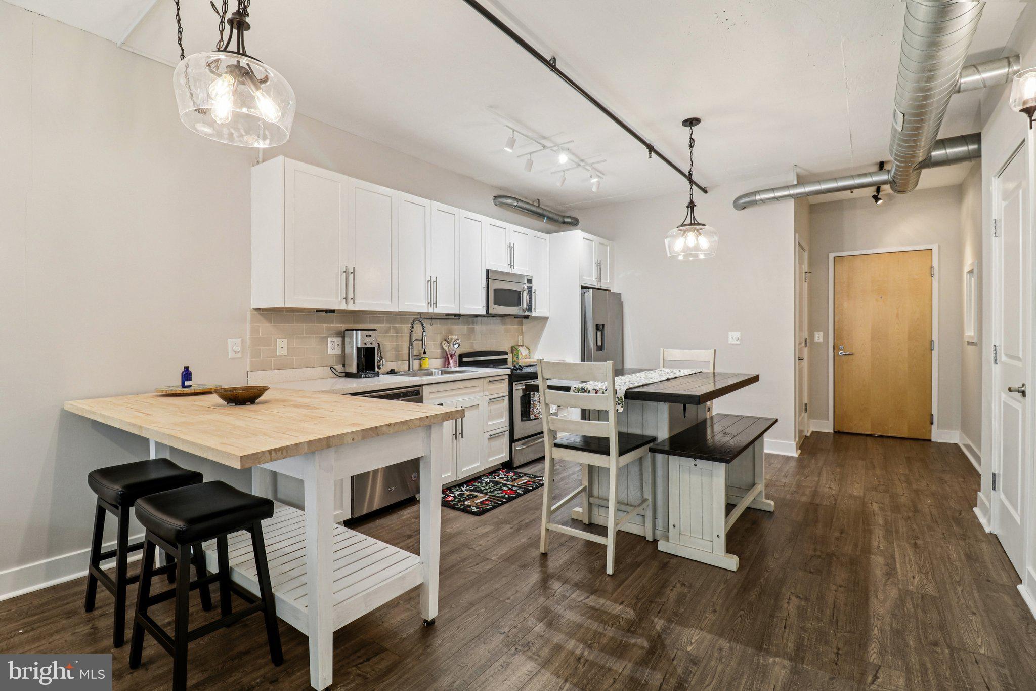 2125 14th Street Northwest, Unit 322 Washington, DC 20009 - Photo 1 of 37 a kitchen with a dining table chairs and white cabinets