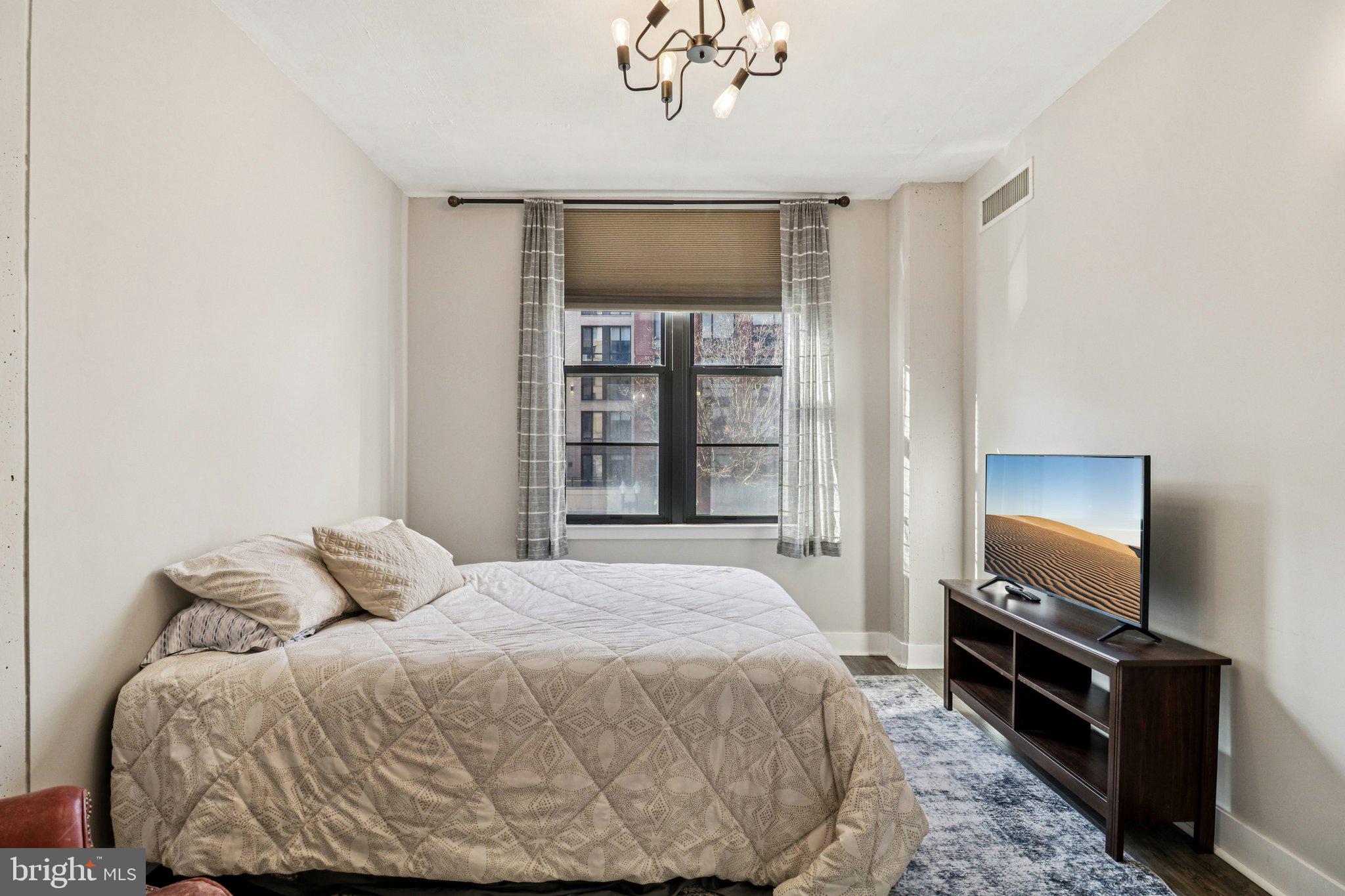 2125 14th Street Northwest, Unit 322 Washington, DC 20009 - Photo 28 of 37 a bedroom with a bed and a flat screen tv