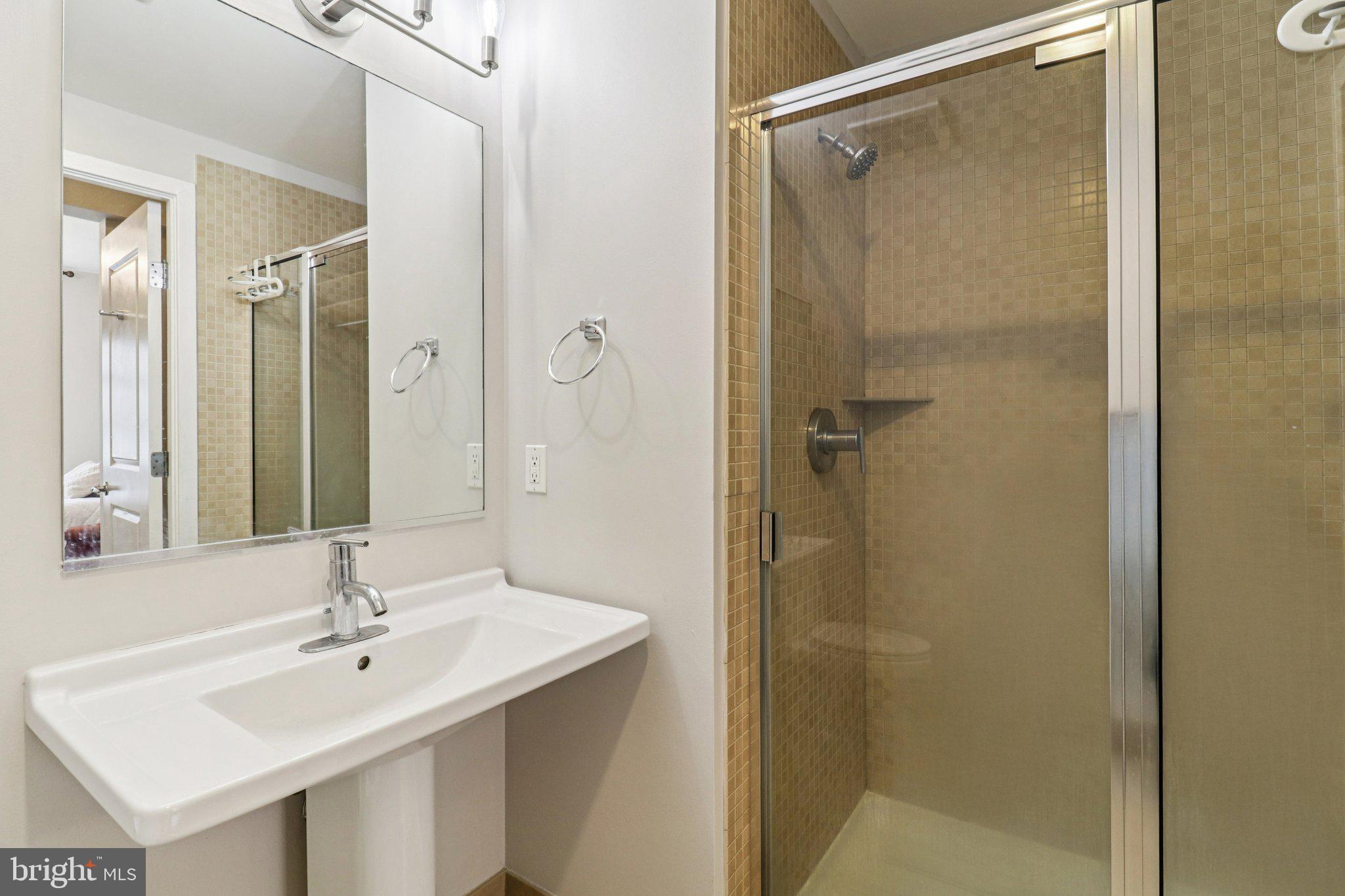 2125 14th Street Northwest, Unit 322 Washington, DC 20009 - Photo 33 of 37 a bathroom with a sink mirror and shower