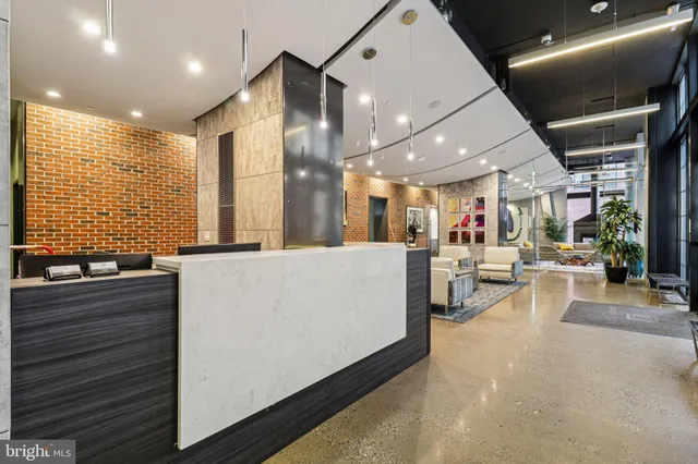 a living room with stainless steel appliances kitchen island lots of furniture and a large window