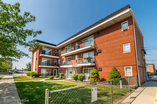 a front view of a residential apartment building with a yard