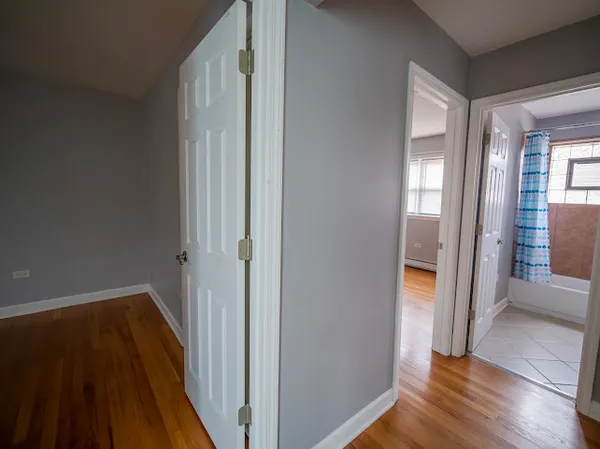 a view of a hallway with wooden floor and glass door