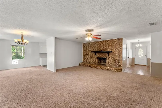 an empty room with windows and fireplace